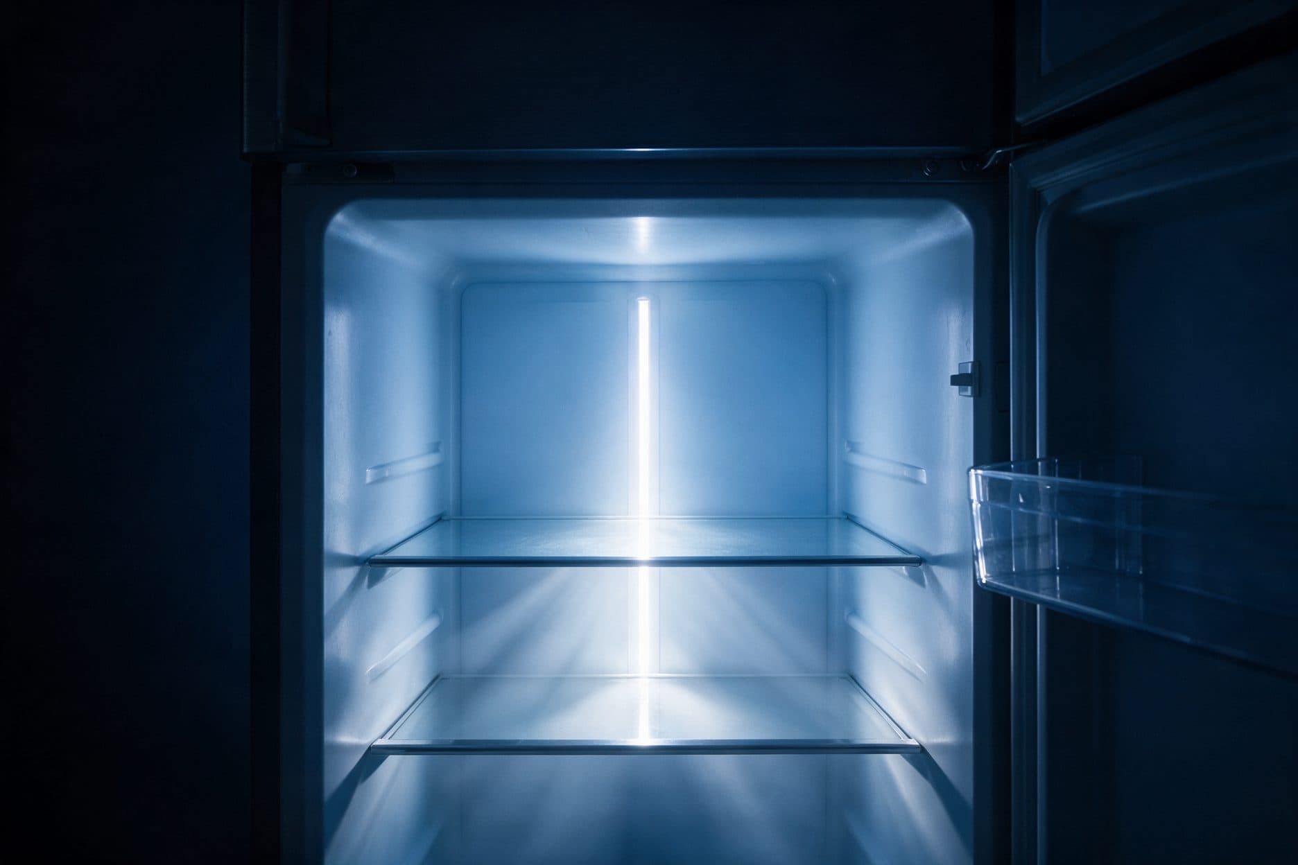 The open refrigerator's empty interior glows with a vertical blue-white LED strip down the back wall, lighting two glass shelves and a door bin against an otherwise near-black cabinet.